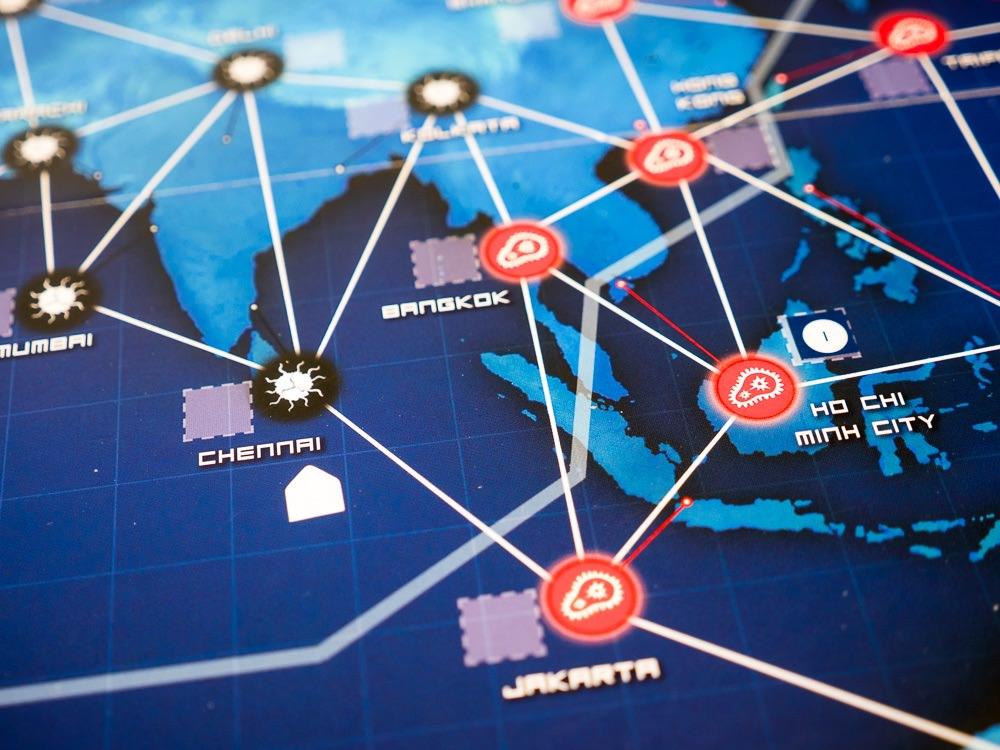 Lähikuva Pandemic Legacy: Season 1:n pelilaudasta Kaakkois-Aasiasta. Ho Chi Minh Cityn viereen on liimattu tarra "1".