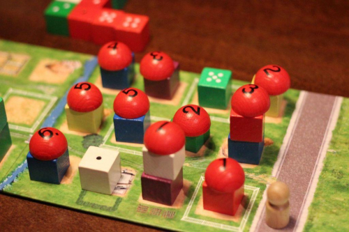 Die Neue Heimat -pelin pelilauta, jolla on rakennuskuutioita ja kattokupoleita.