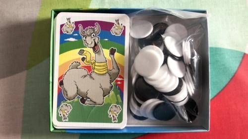 L.A.M.A.:n laatikossa korttipakka ja pussillinen pelimerkkejä
