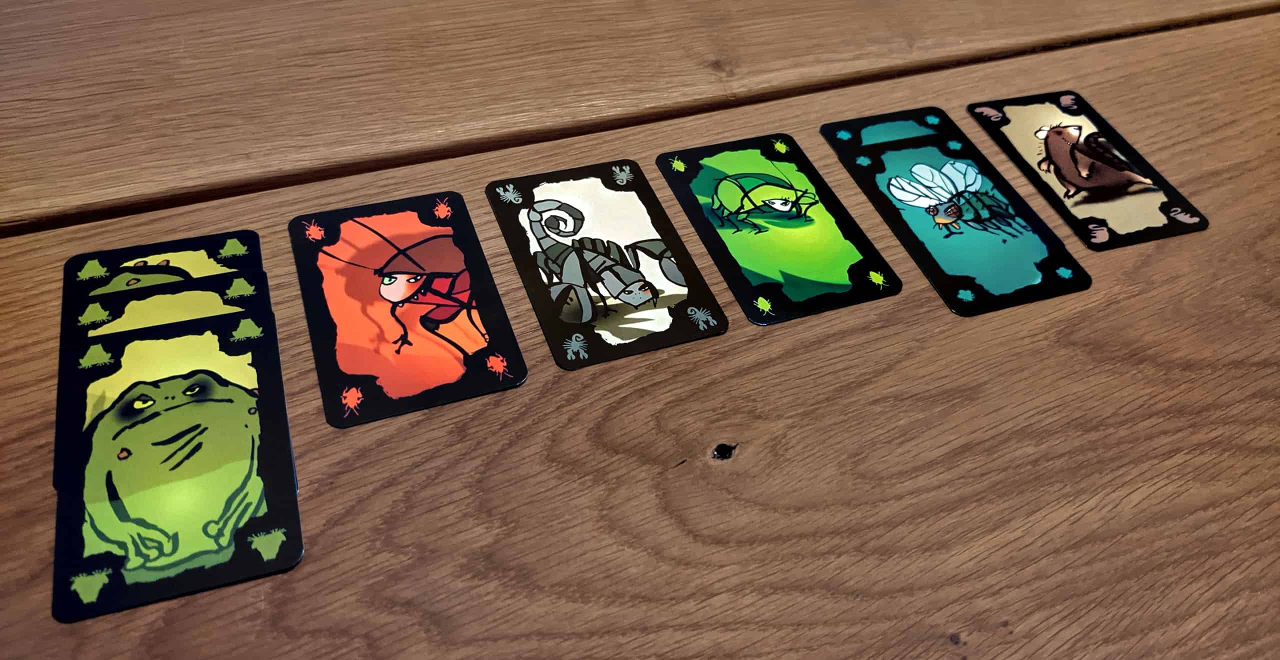 Torakkapokerin kerättyjä kortteja: kolme sammakkoa uhkaa katkaista pelin.
