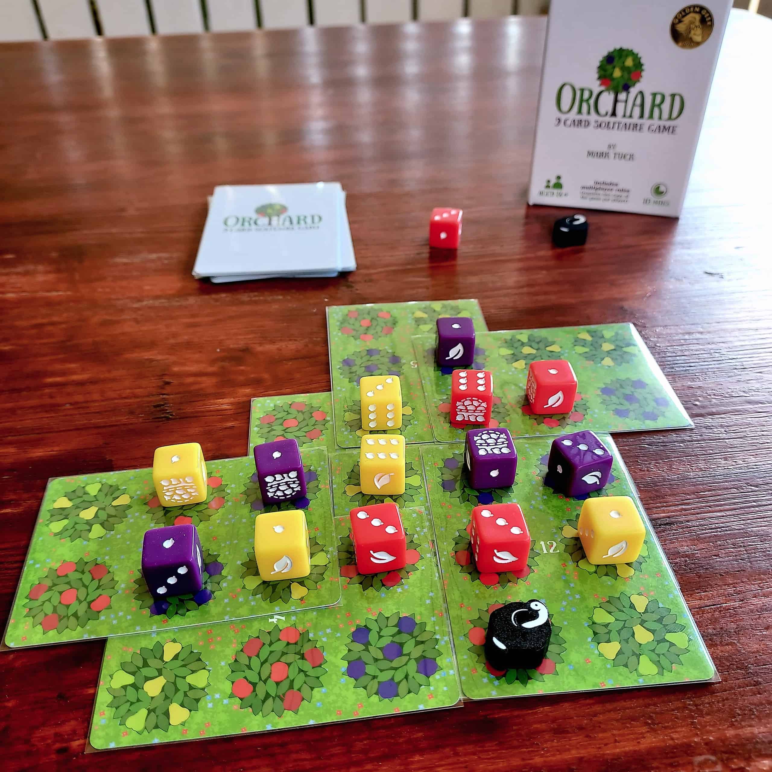 Orchard-peli pöydällä: vihreitä kortteja lomittain, niiden päällä värikkäitä noppia.