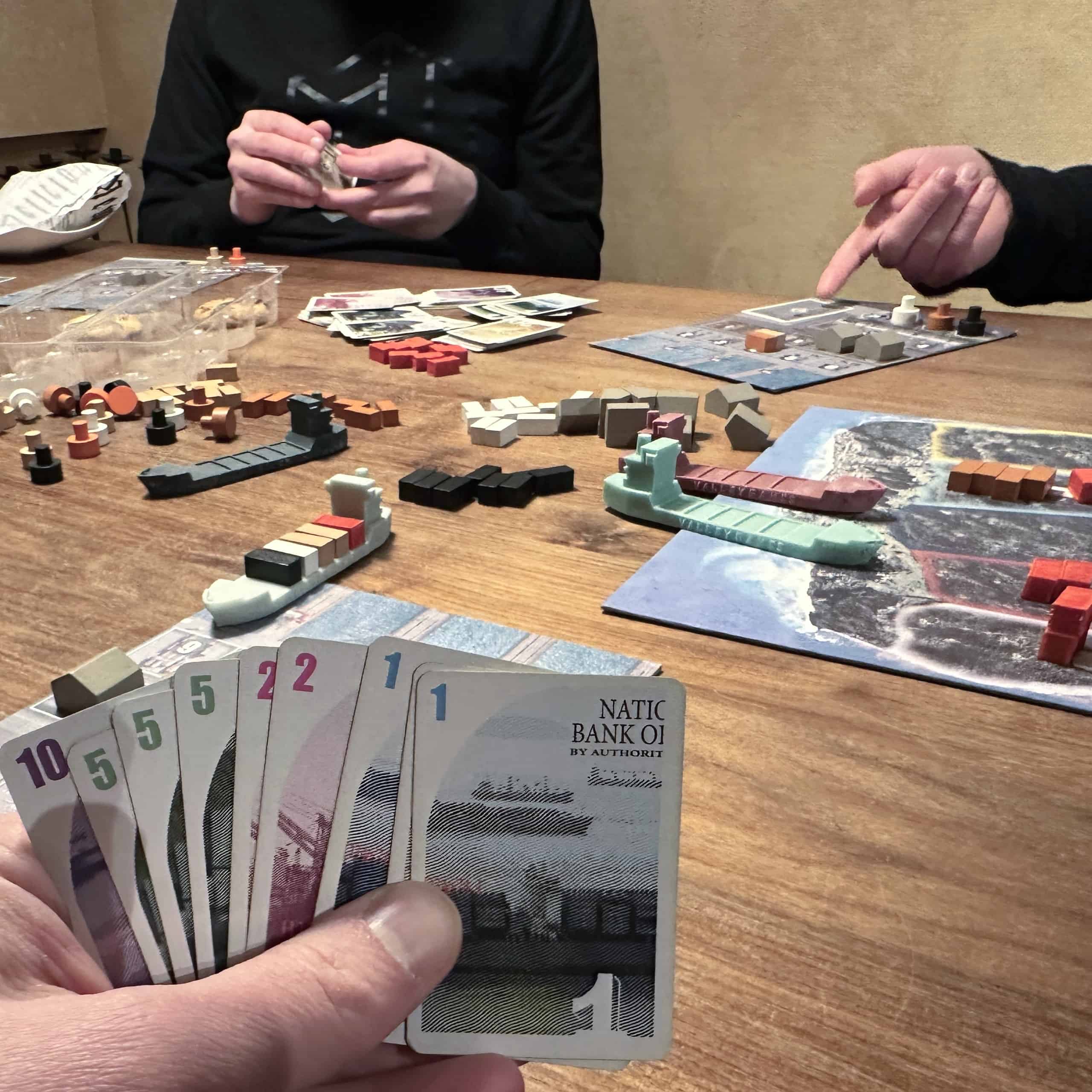 Pelaajalla 32 rahaa kädessä, taustalla kontteja ja konttilaivoja.