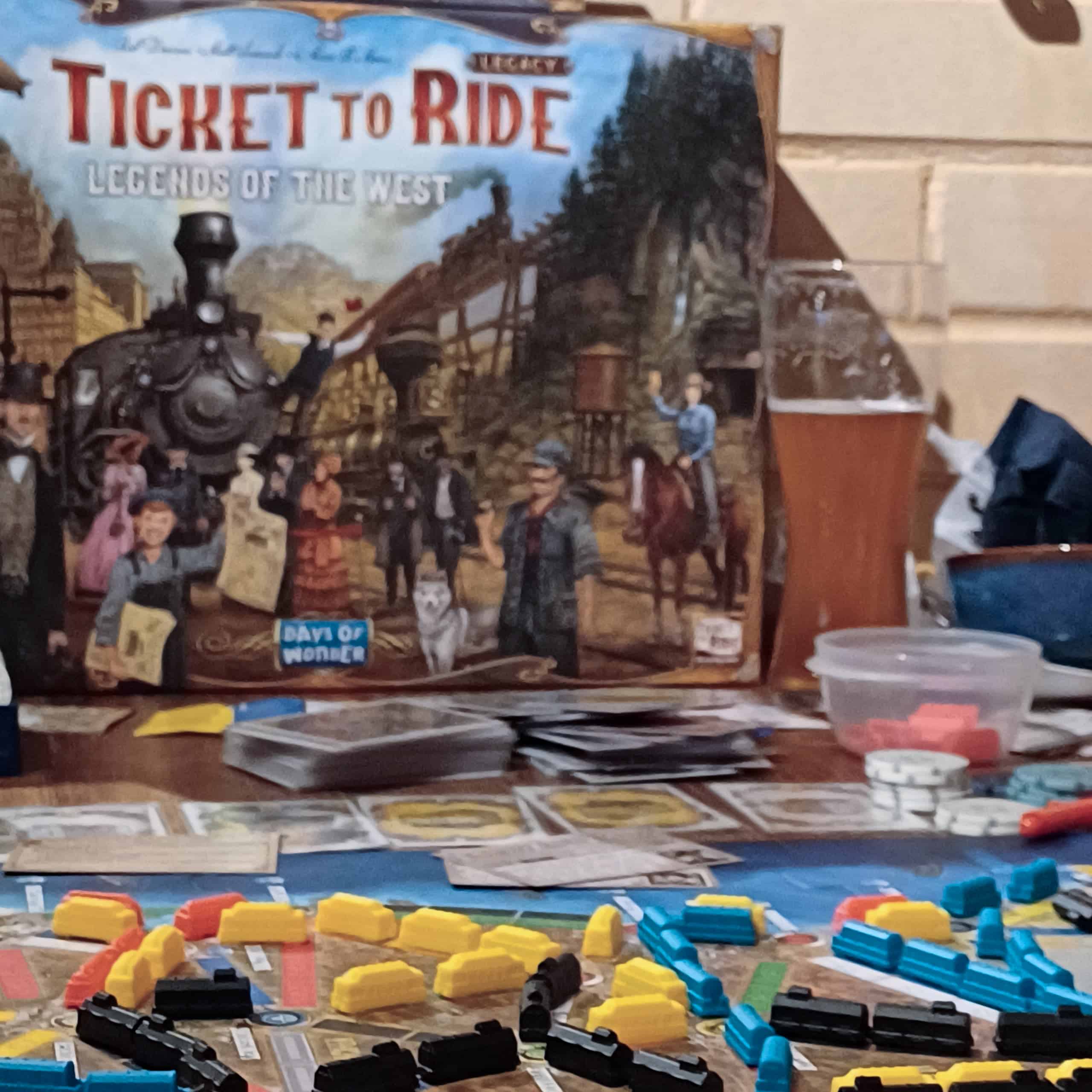 Ticket to Ride: Legends of the Westin laatikko taustalla, etualalla pelilautaa, joka on täynnä junamarkkereita.