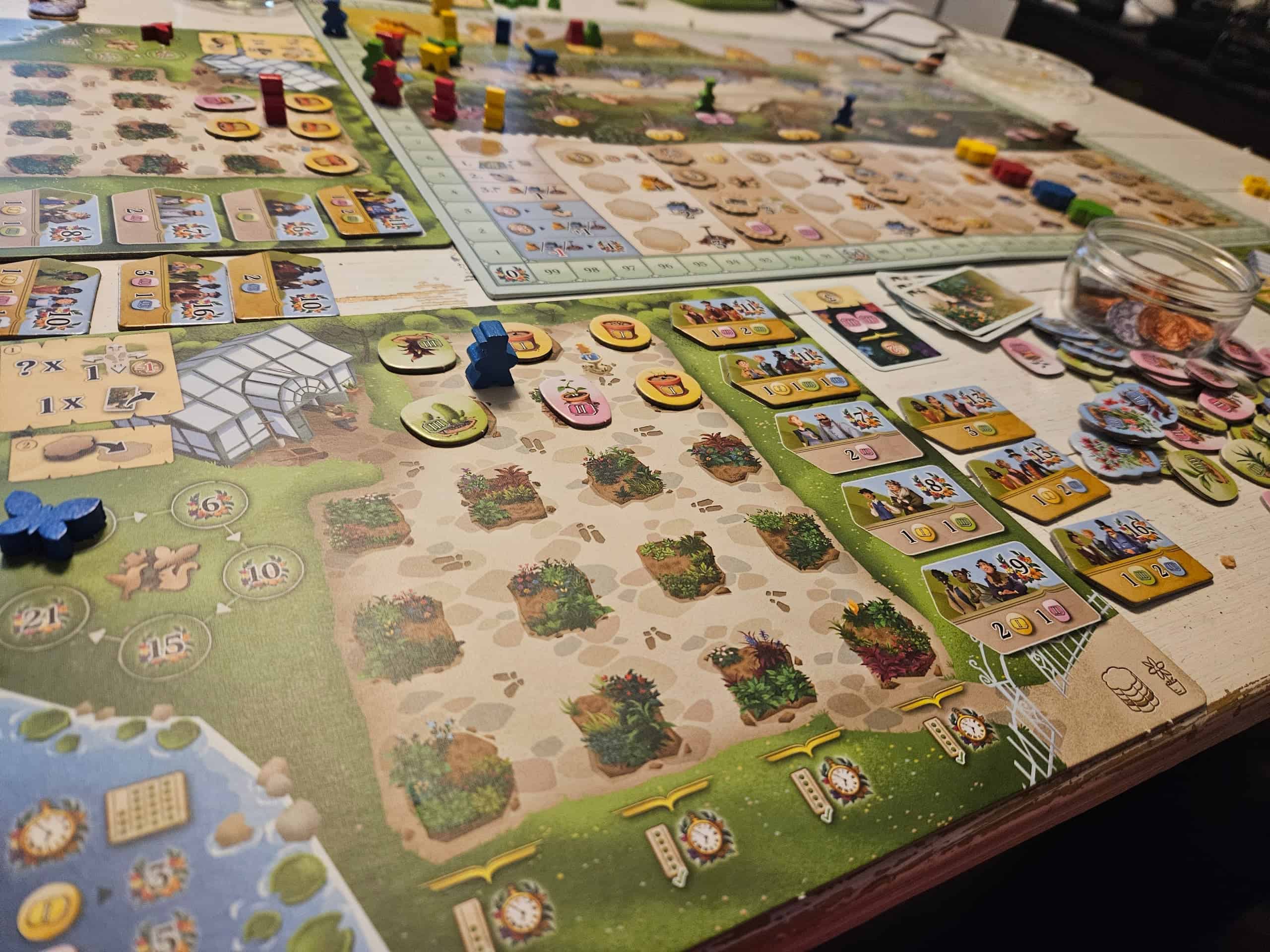 Etualalla Botanicuksen pelaajalauta, taustalla yhteinen pelilauta ja toisen pelaajan oma pelilauta. Pelistä on toiminnonvalintanappuloiden etenemisen perusteella pelattu noin puolet.