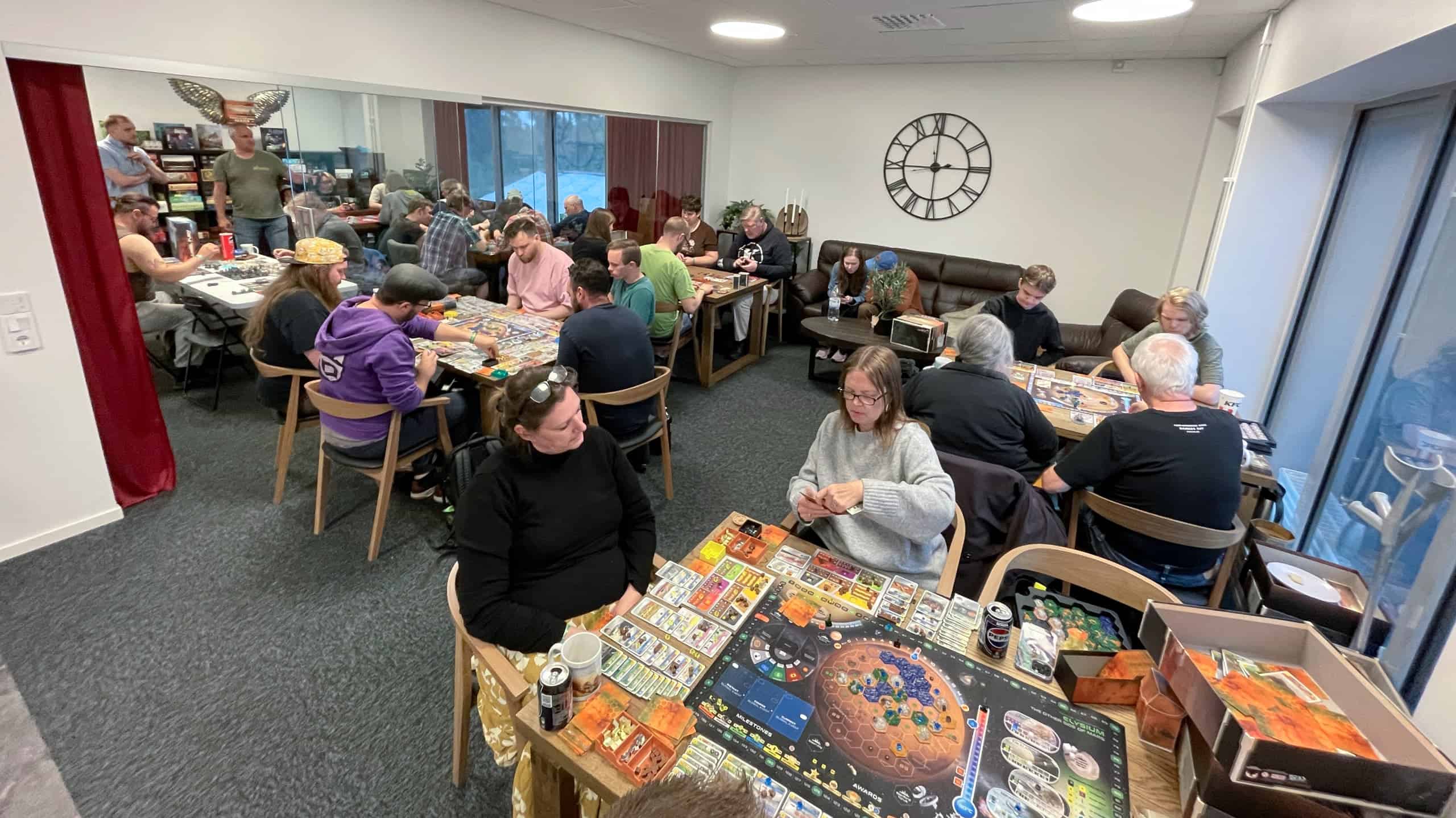 Yleiskuvaa Fryxconin pelitiloista. Parissa vierekkäisessä huoneessa on monta pelipöytää, joista ainakin kolmella pelataan Terraforming Marsia.