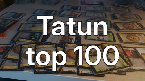 Tatun top 100 -teksti, taustallaan Dominionin kortteja
