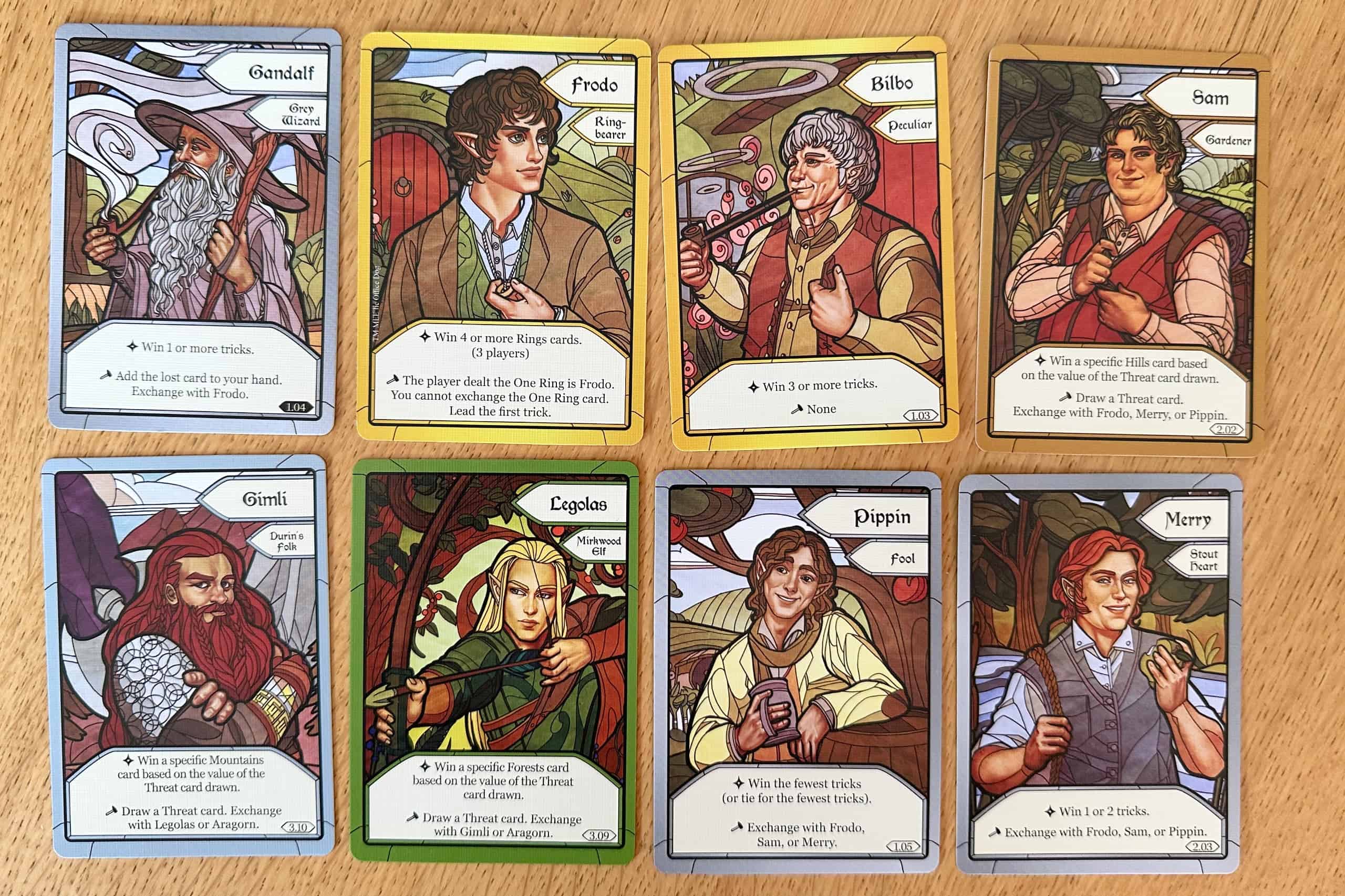 Kahdeksan pelin hahmokorttia: Gandalf, Frodo, Bilbo, Sam, Gimli, Legolas, Pippin ja Merri. Hahmot on kuvitettu lasimaalauksia muistuttavalla tyylillä.