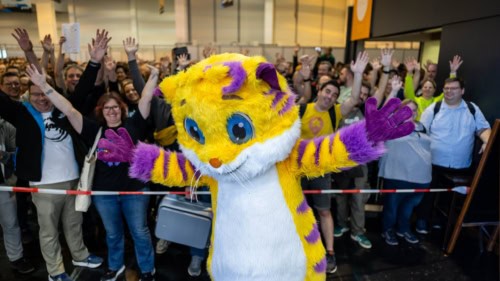 Essenin Spiel-messujen Meeps-maskotti takanaan riemuitseva yleisöjoukko.