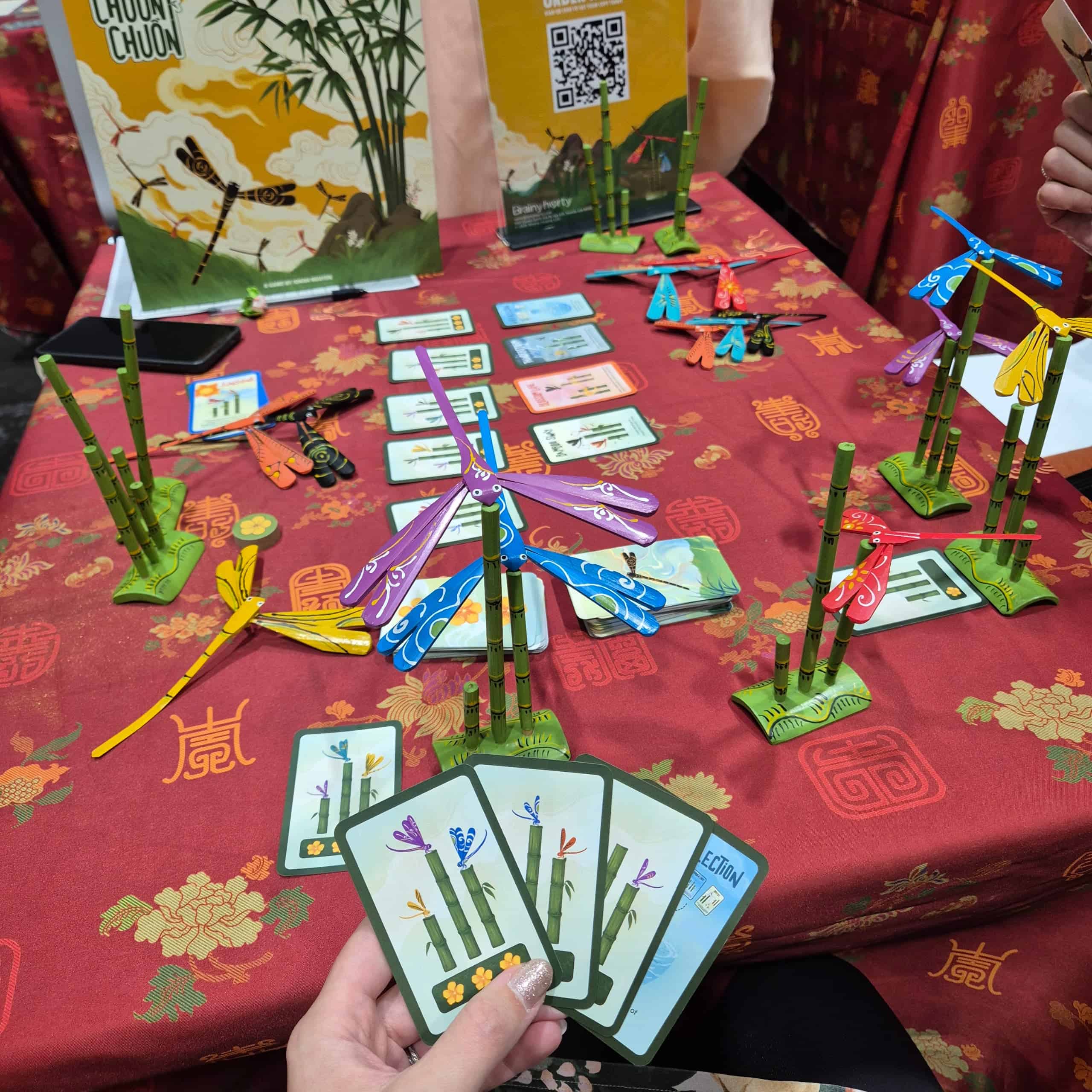 Chuồn Chuồn -pelissä rakennetaan puisia bambupylväitä, joiden päihin tulee isoja puisia sudenkorentoja. Vilma pitelee kädessään muutamaa korttia, joissa on tavoitteita bambujen pituuden ja sudenkorentojen värin suhteen. 