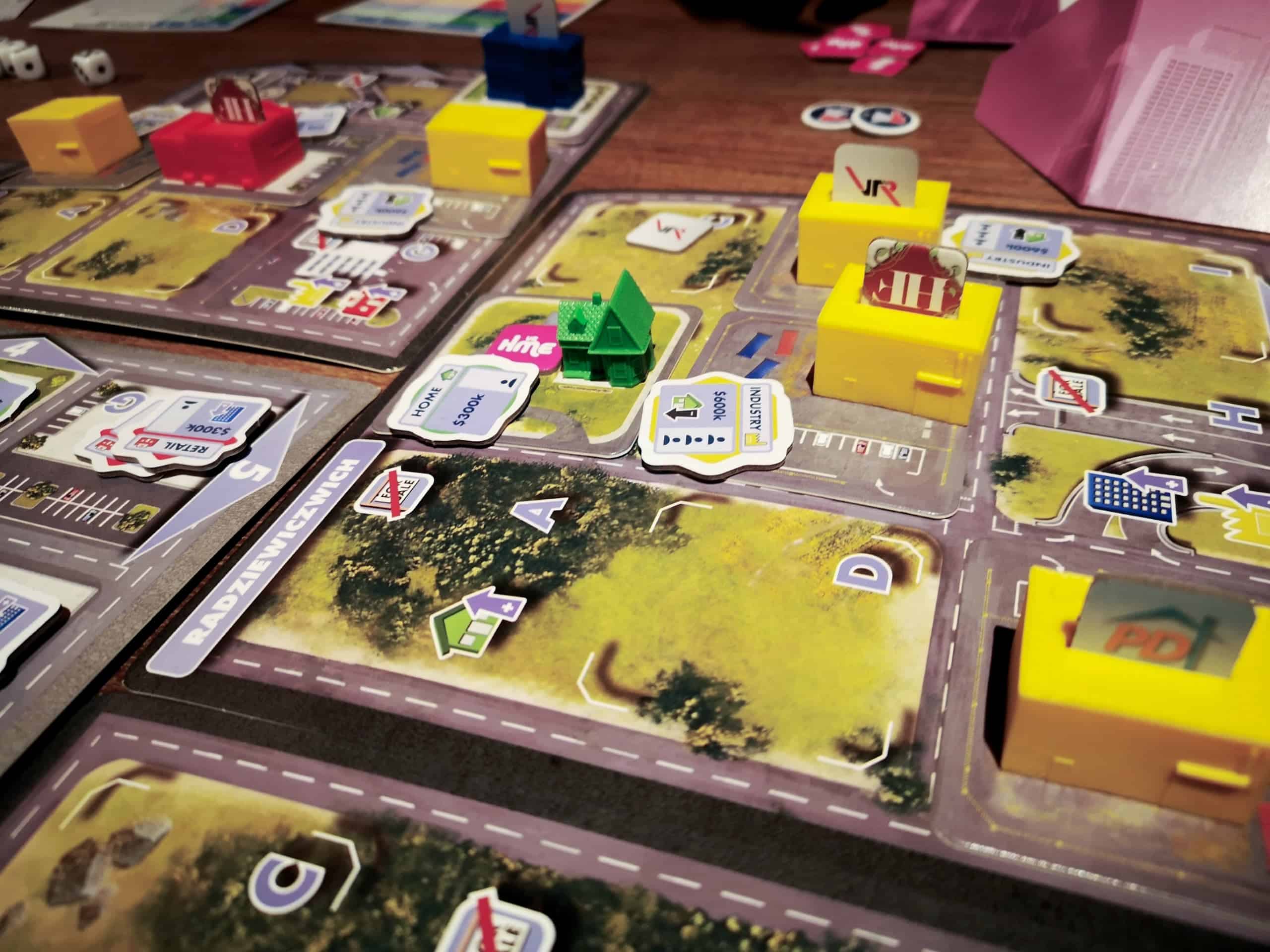 Lähikuva pelilaudasta. Naapurustossa on kaikkien pelaajien rakennuksia.