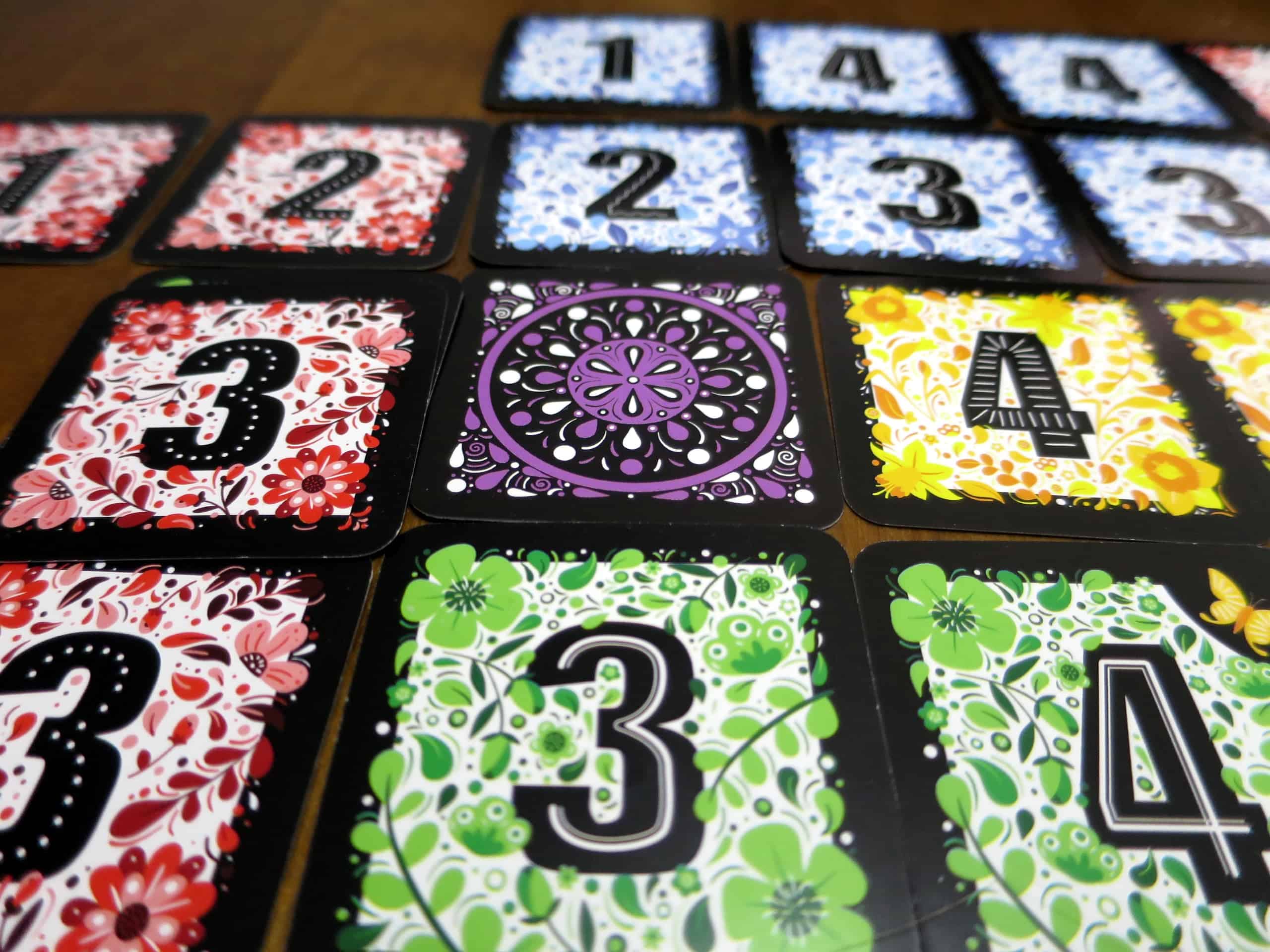 Korttien keskellä on violetti kortti, jonka ympärille muut kortit levittyvät.