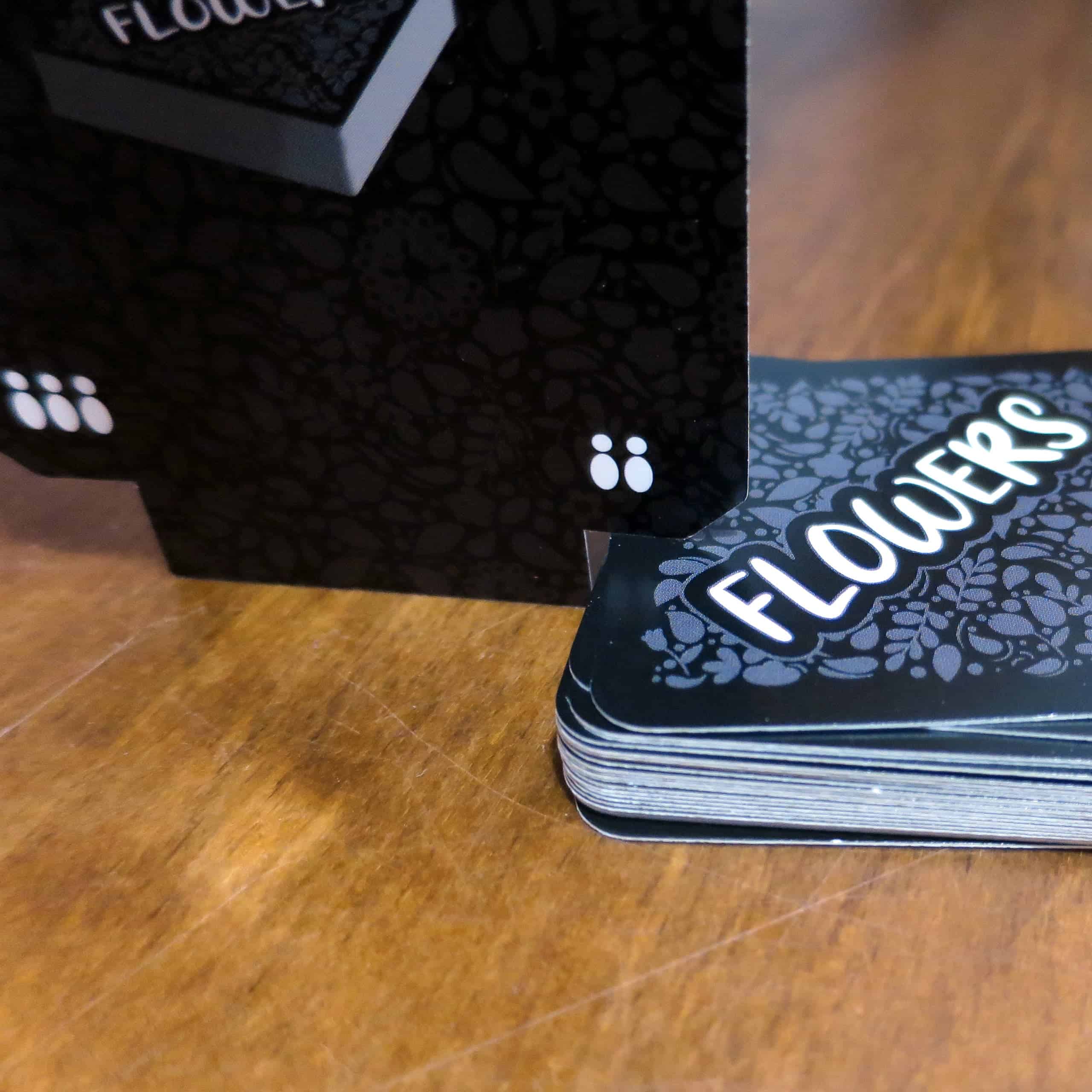 Lähikuva kulmista lovetusta kortista ja sopivan kokoiseksi mitattu korttipakka.