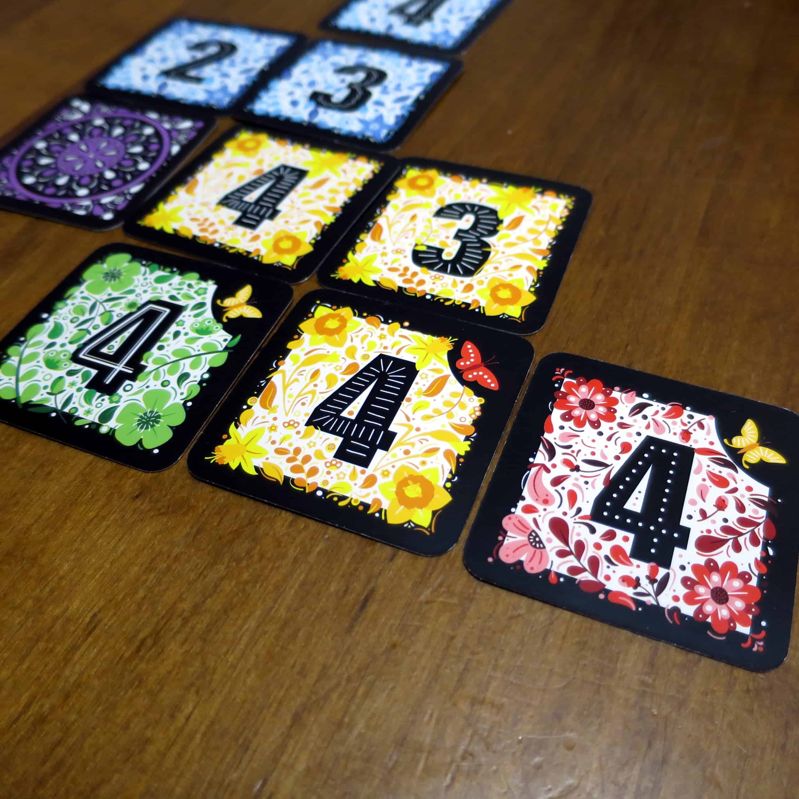 Kolme vierekkäistä 4-korttia, joissa jokaisessa on kulmassa perhonen.