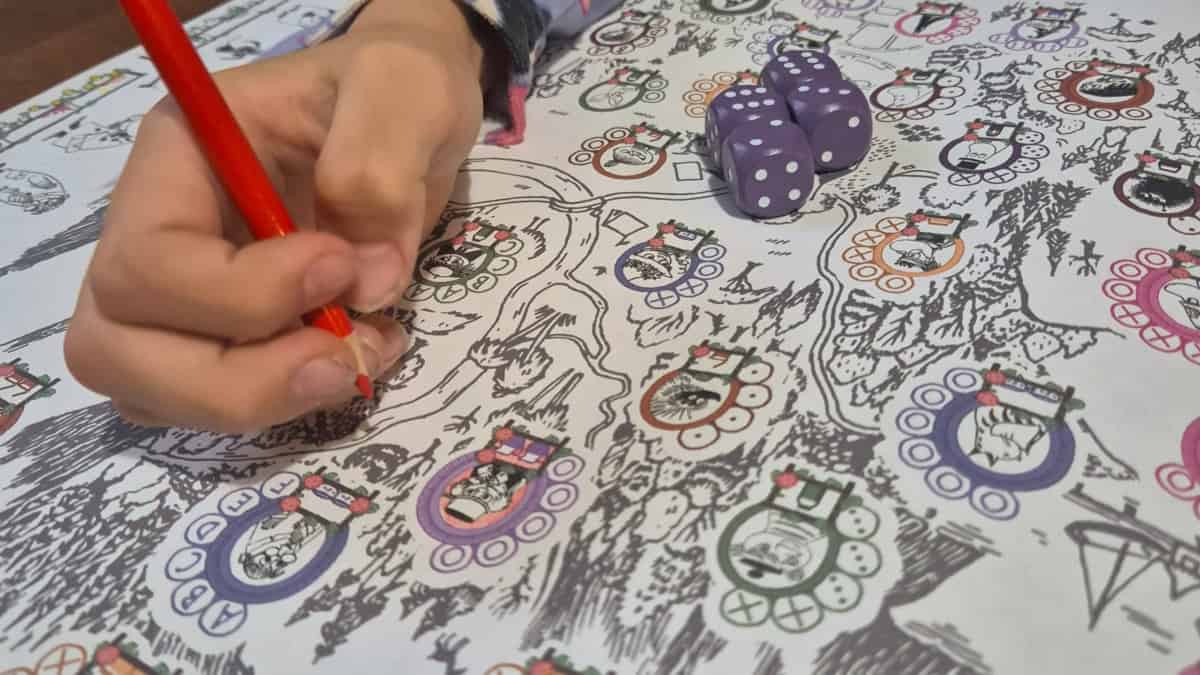 Lähikuva Stegegets: Moominin kupongista, jossa on väritettäviä muumihahmoja. Kupongin päällä on lapsen käsi, joka pitelee kynää.