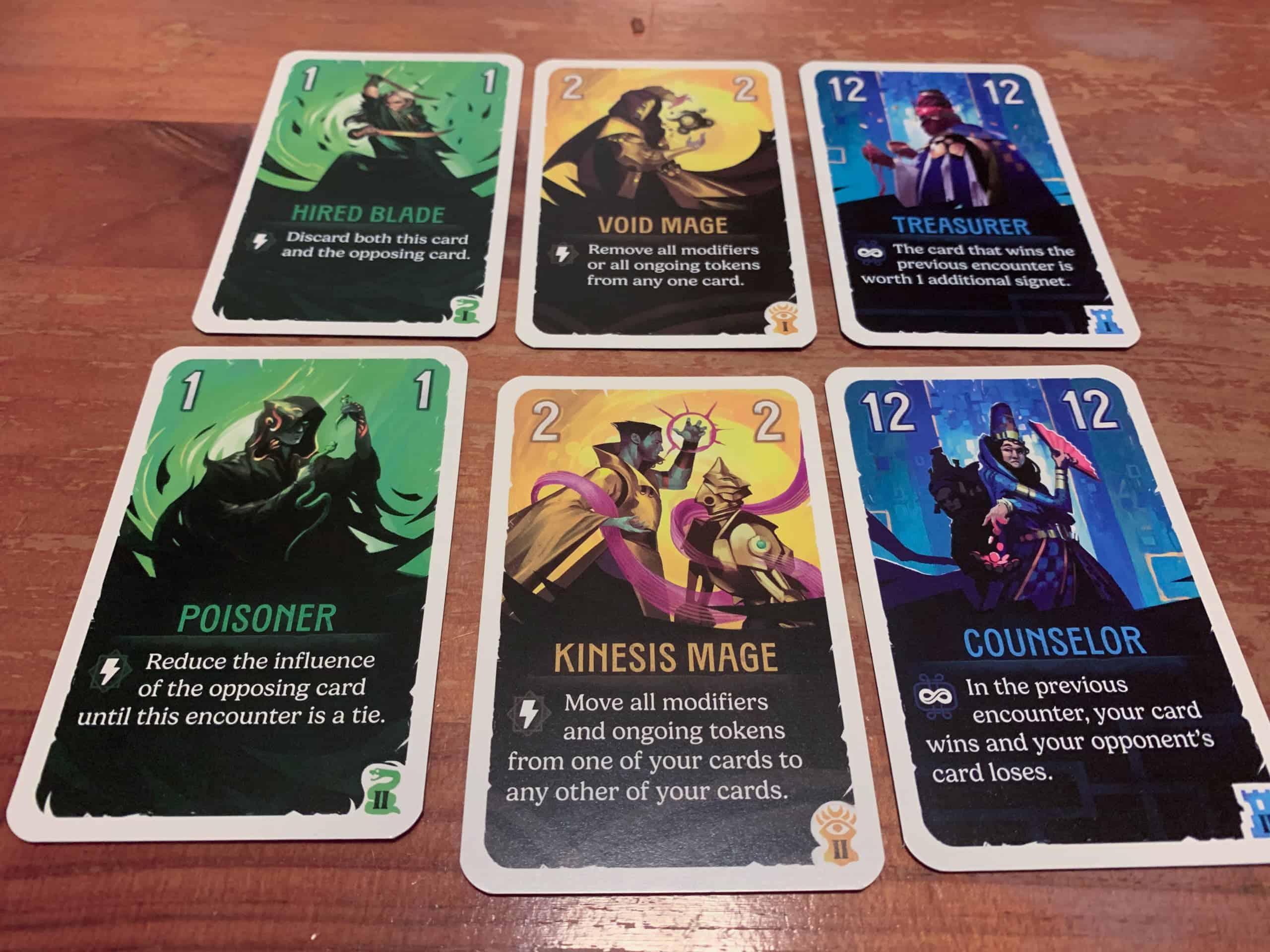 Kaksi kolmen kortin riviä, joissa on toisiaan vastaavat kortit eri pakoista.