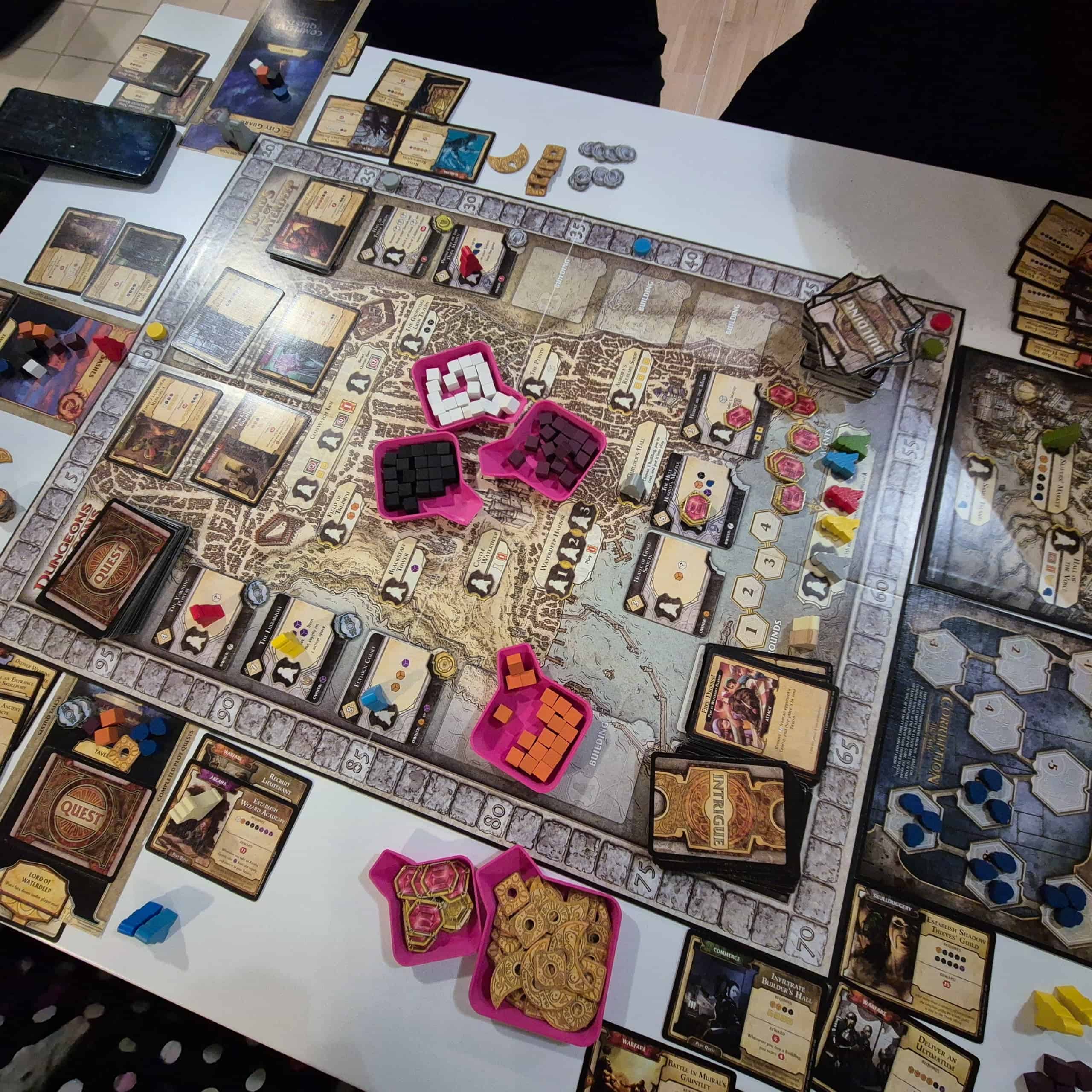 Lords of Waterdeepin pelilauta, jonka päällä pinkkejä kippoja komponenteille.