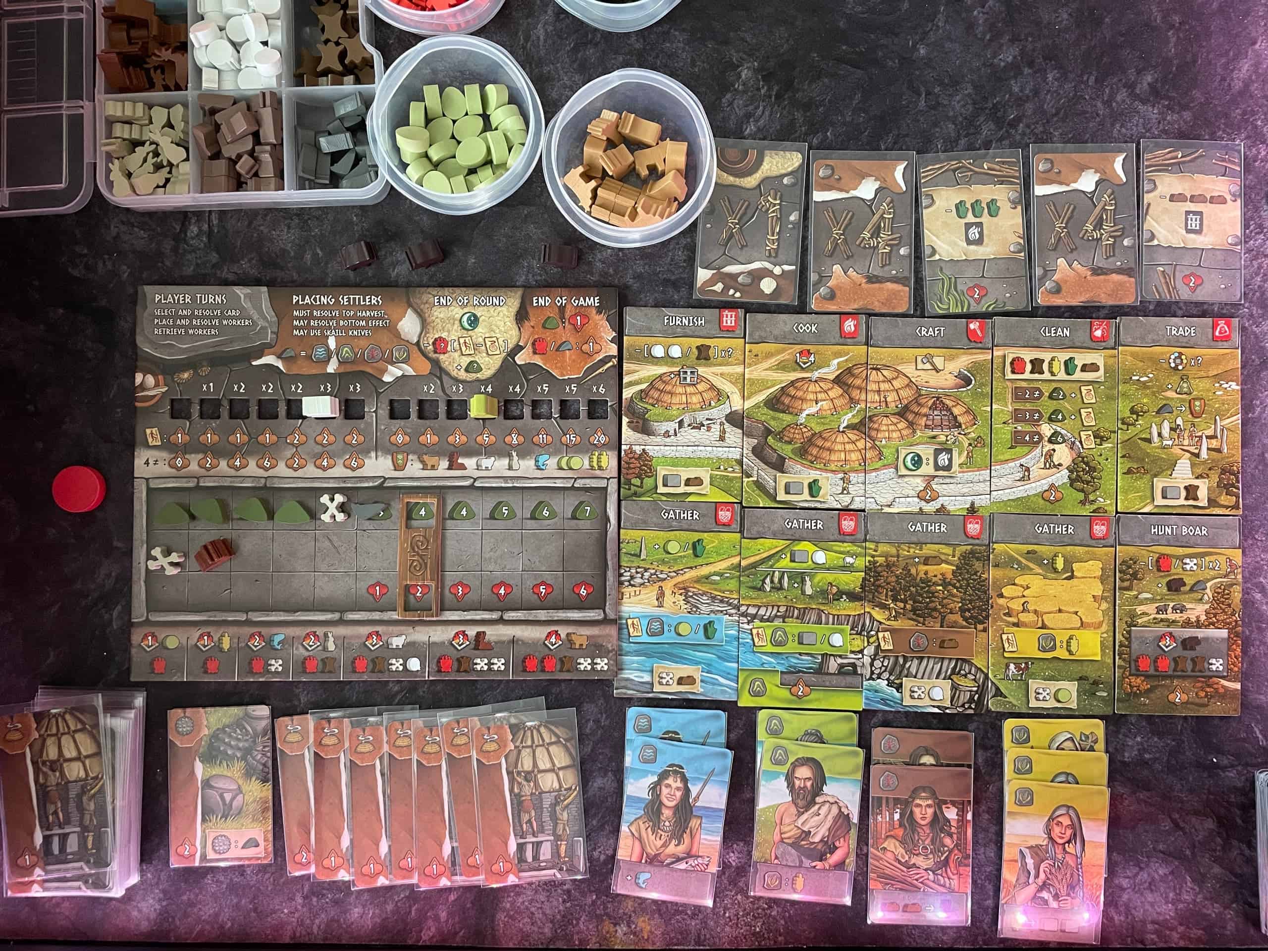 Yksinpelin pelilauta, toimintolaatat, kortit ja nappulat.