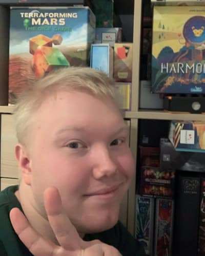 Valokuva Veeti Kainulaisesta pelihyllyn edessä