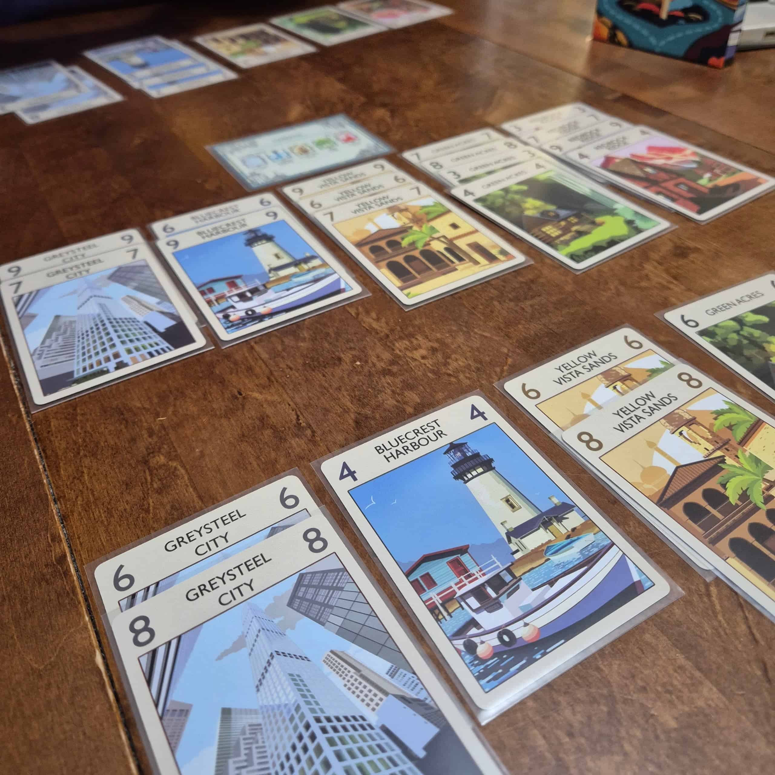 Lähikuva Forks-pelin korteista, joihin on kuvattu art deco -tyylisiä matkailumainosjulisteita.