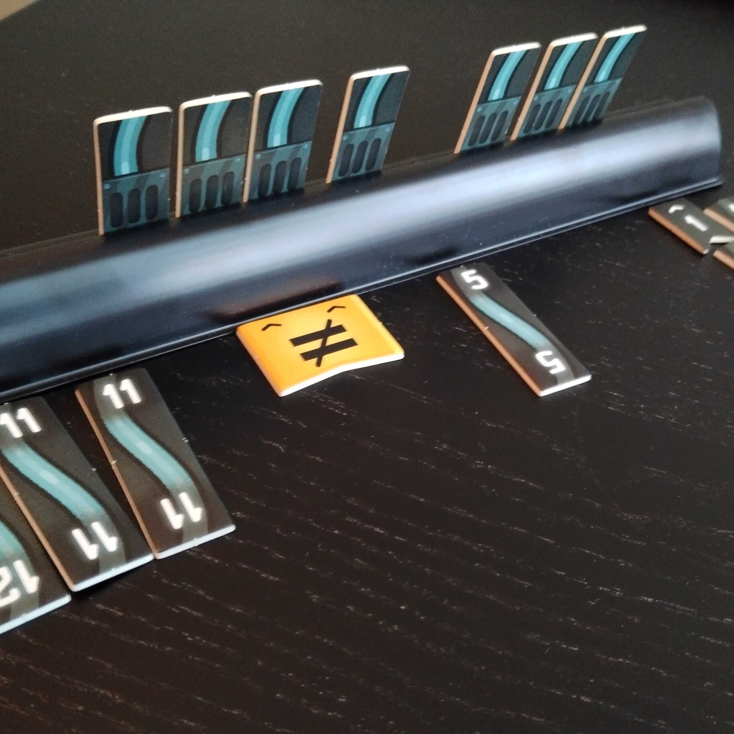 Pelaajan johtotelineen edessä on keltainen laatta, jossa on epäyhtäsuuruusmerkki.