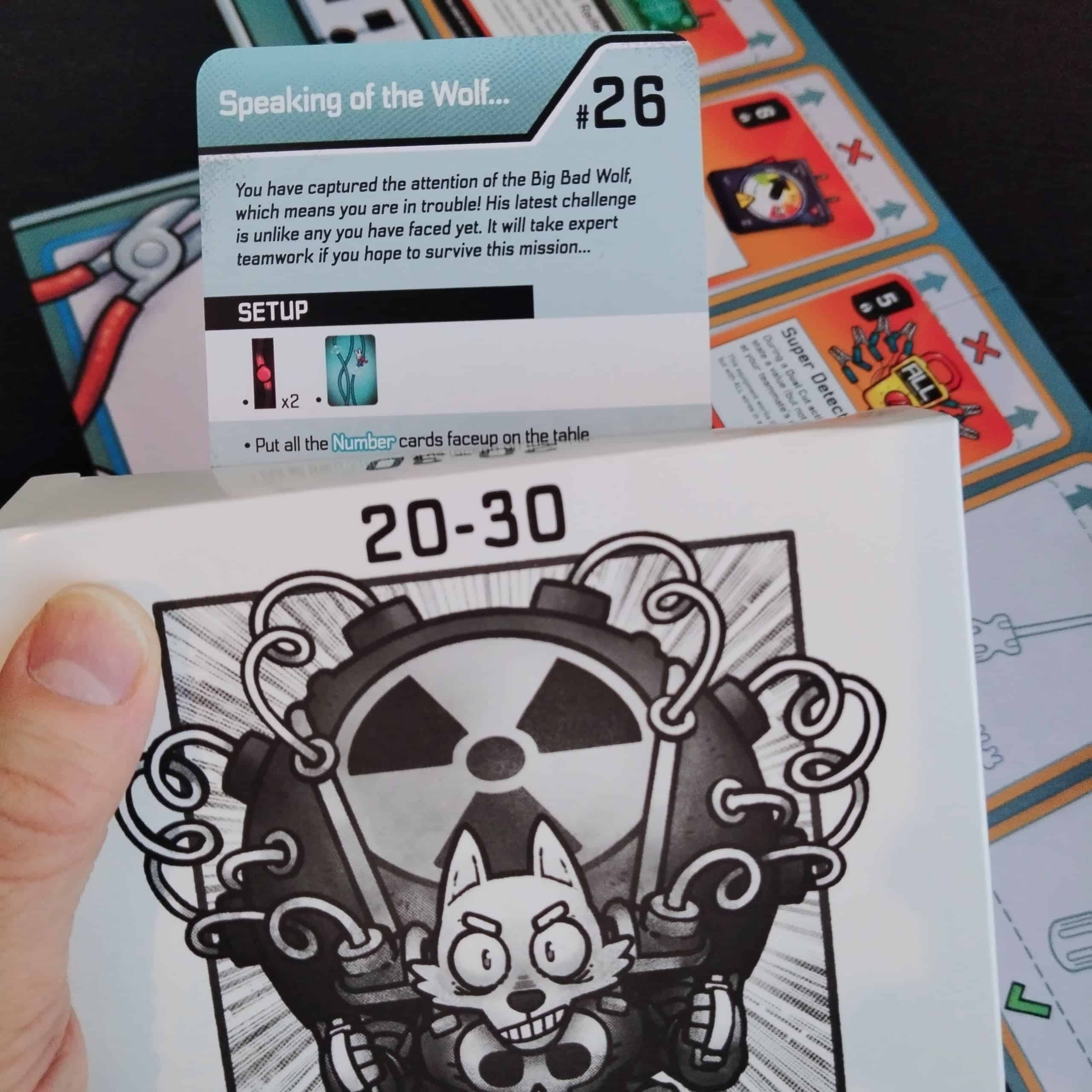 Iso paha susi -laatikko, jossa on skenaariot 20–30. Taustalla näkyy tehtävän 26 ohjekortti.