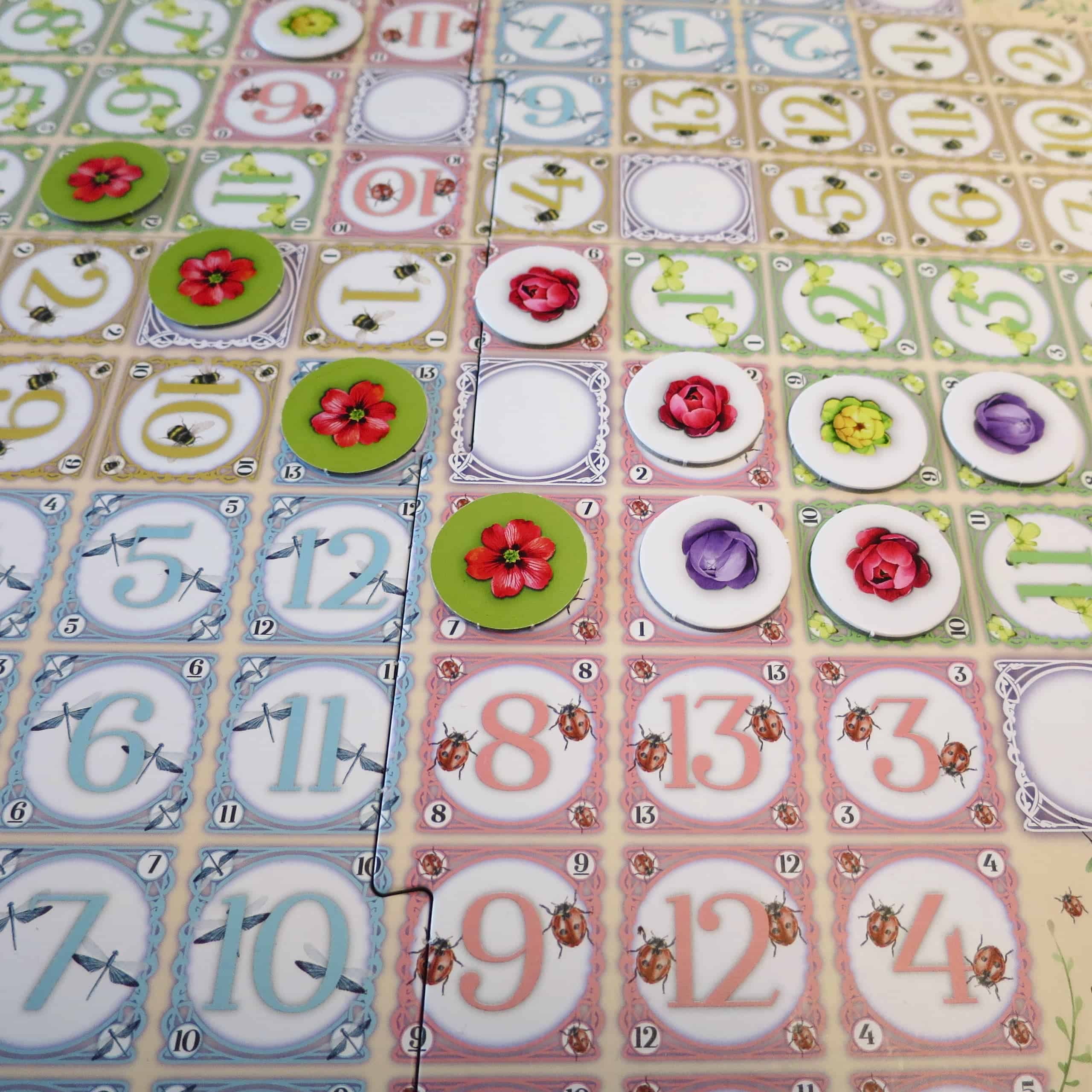 Lähikuva Botanical Blissin pelilaudasta, jossa punaisia kukkia on kaksi vinoviivaa: toisessa on täydet neljä, toisessa kolme.