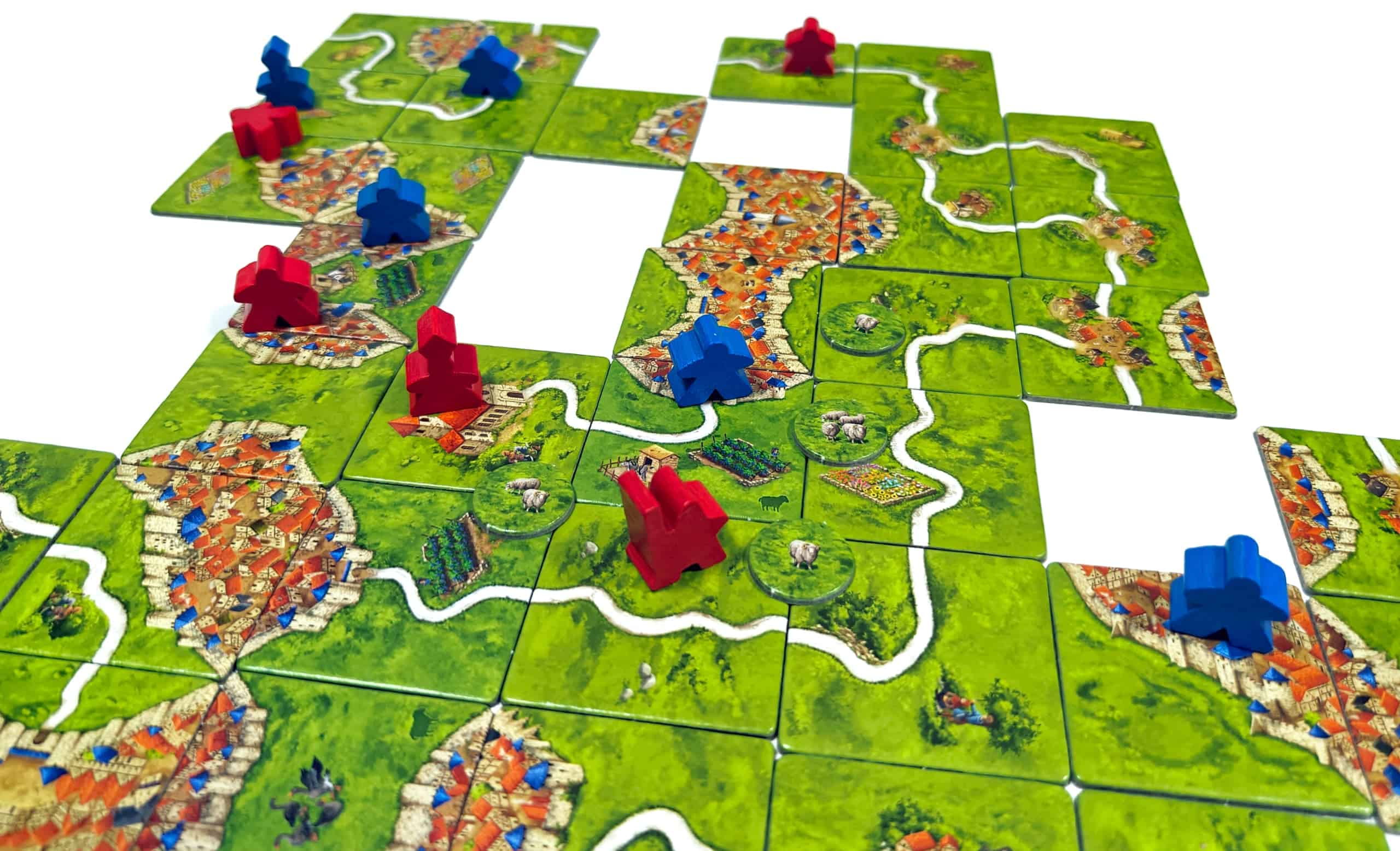 Lähikuva pelilaudasta, jossa apotti on lähes valmiissa luostarissa. Luostarin viereisellä pellolla on kahdeksan lampaan lauma ja paimen. Laatoilla näkyy myös viinitarhoja.