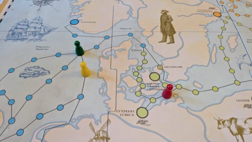 Lähikuva Raumanmeren laivanvarustajien pelilaudasta kuvaa Tanskan ympäristöä. Merellä menee laivareittejä, joita pitkin pelaajien nappulat liikkuvat.