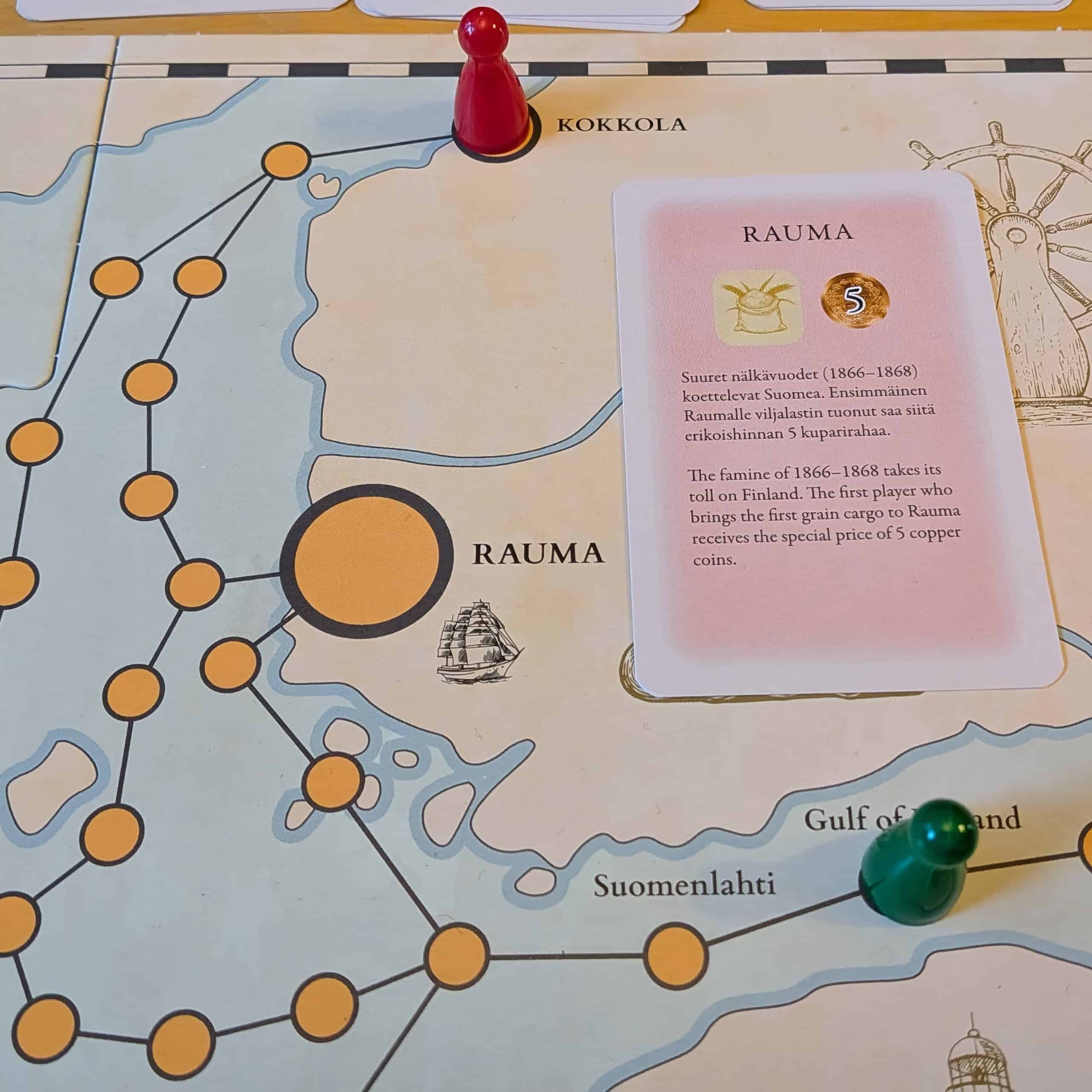 Lähikuva pelilaudan Suomea kuvaavasta osasta. Suomessa on vain Kokkola ja Rauma. Laudalla on kortti, jossa nälkävuodet koettelevat Suomea ja Raumassa maksetaan viljalastista lisäkorvaus.