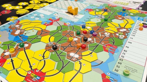 Lähikuva 18GB:n pelilaudasta. Laudan alareunassa näkyy Lontoo, yläreuna ulottuu Skotlantiin asti. Lauta on täynnä rataverkkoa kuvaavia keltaisia, vihreitä ja ruskeita heksan muotoisia pahvilaattoja.
