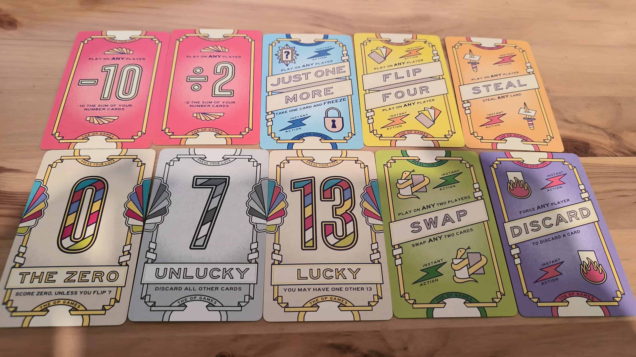 Kymmenen Flip 7: With a Vengeancen korttia: -10, jako kahdella, "Just One More", "Flip Four", "Steal", nolla, "Unlucky 7", "Lucky 13", "Swap" ja "Discard".