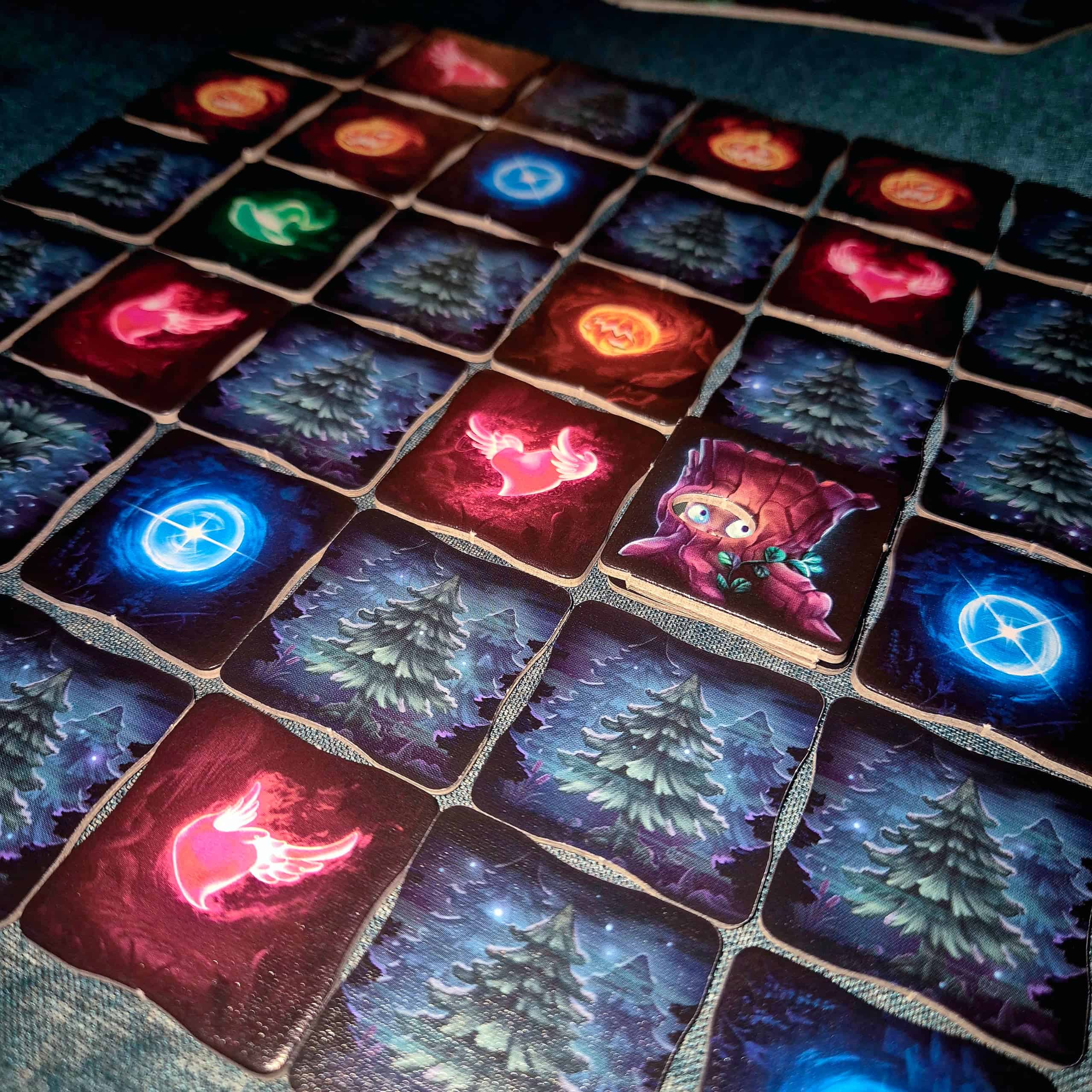 Lähikuva Wispwoodin ruudukkoon ladotuista laatoista, joissa on öisiä puita ja erilaisia valo-olentoja.