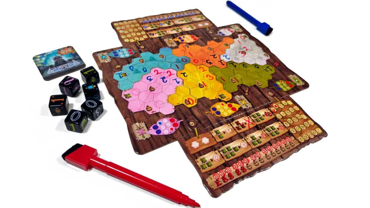 Marabuntan pelilauta, jonka vierellä nopat ja sininen ja punainen tussi. Pelilaudalla on eri värisiä alueita, joihin on merkitty numeroita.
