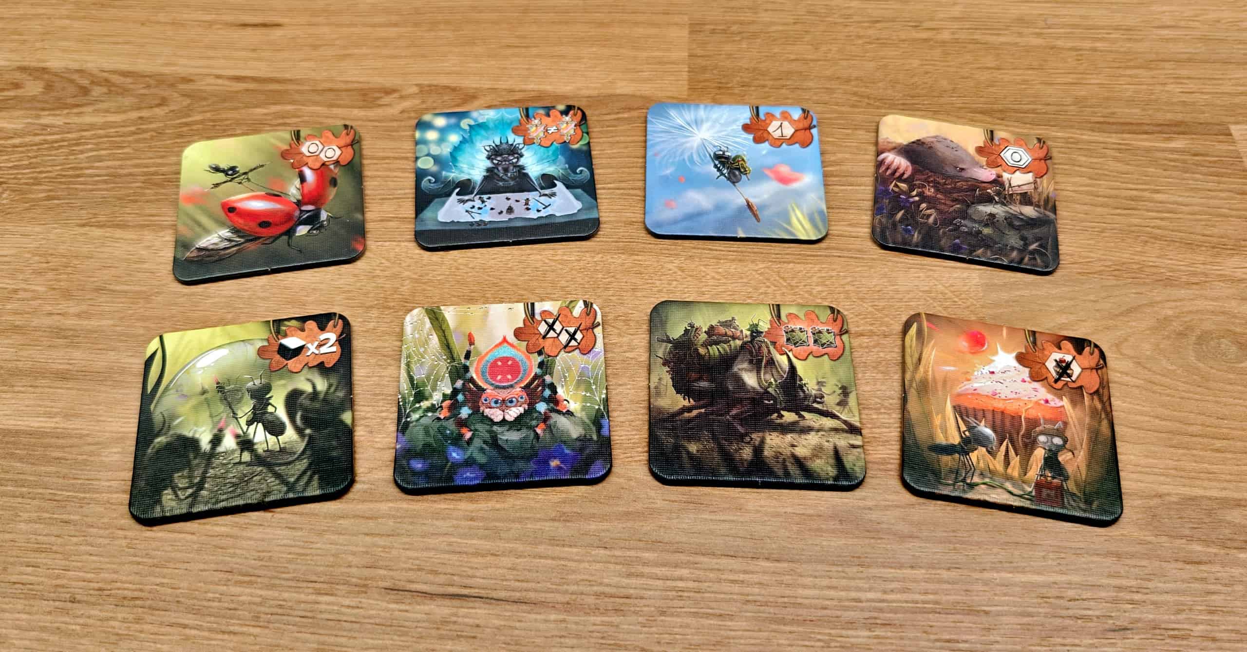 Kahdeksan neliön muotoista pahvilaattaa, jotka kuvaavat eläimiä: muurahainen leppäkertun kyydissä, muurahaiskuningatar, pieni muurahainen voikukan siemenen varassa, myyrä, muurahaisia vesipisaran äärellä, hämähäkki, sarvikuonokas ja muurahaisia räjäyttämässä leivosta.