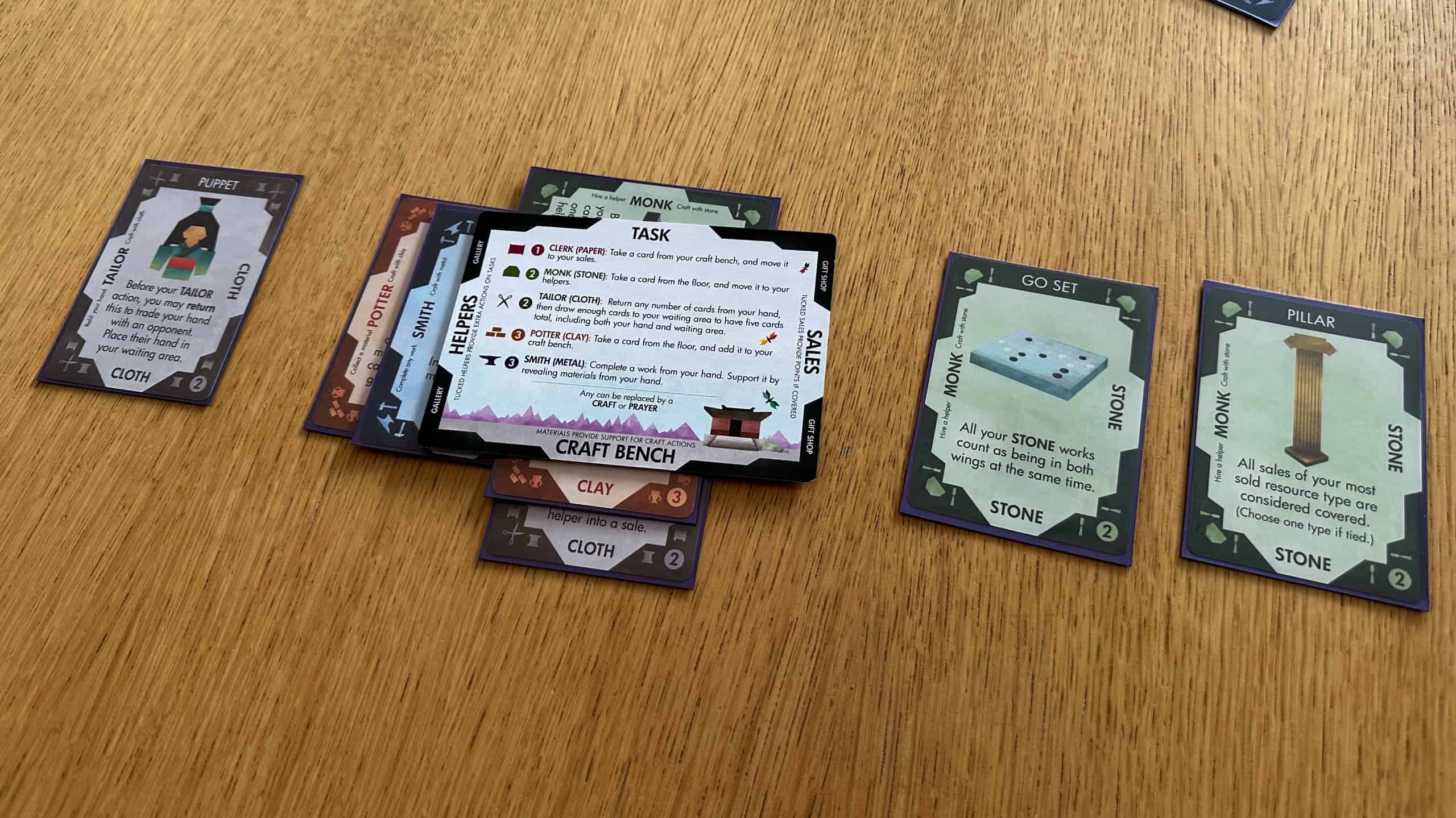 Mottainaissa pelaajan tilanne, jossa apulapun ympärille on pelattu kortteja tehtäväksi, avustajiksi, raaka-aineiksi ja valmiiksi esineiksi. Toisella puolen temppeliä on valmis nukke, toisella taas go-setti ja pilari.