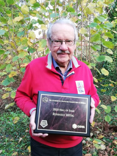 Reinhold Wittig pitelemässä The Academy of Adventure Gaming Arts & Designin Hall of Fame -kunniaplakaattia.