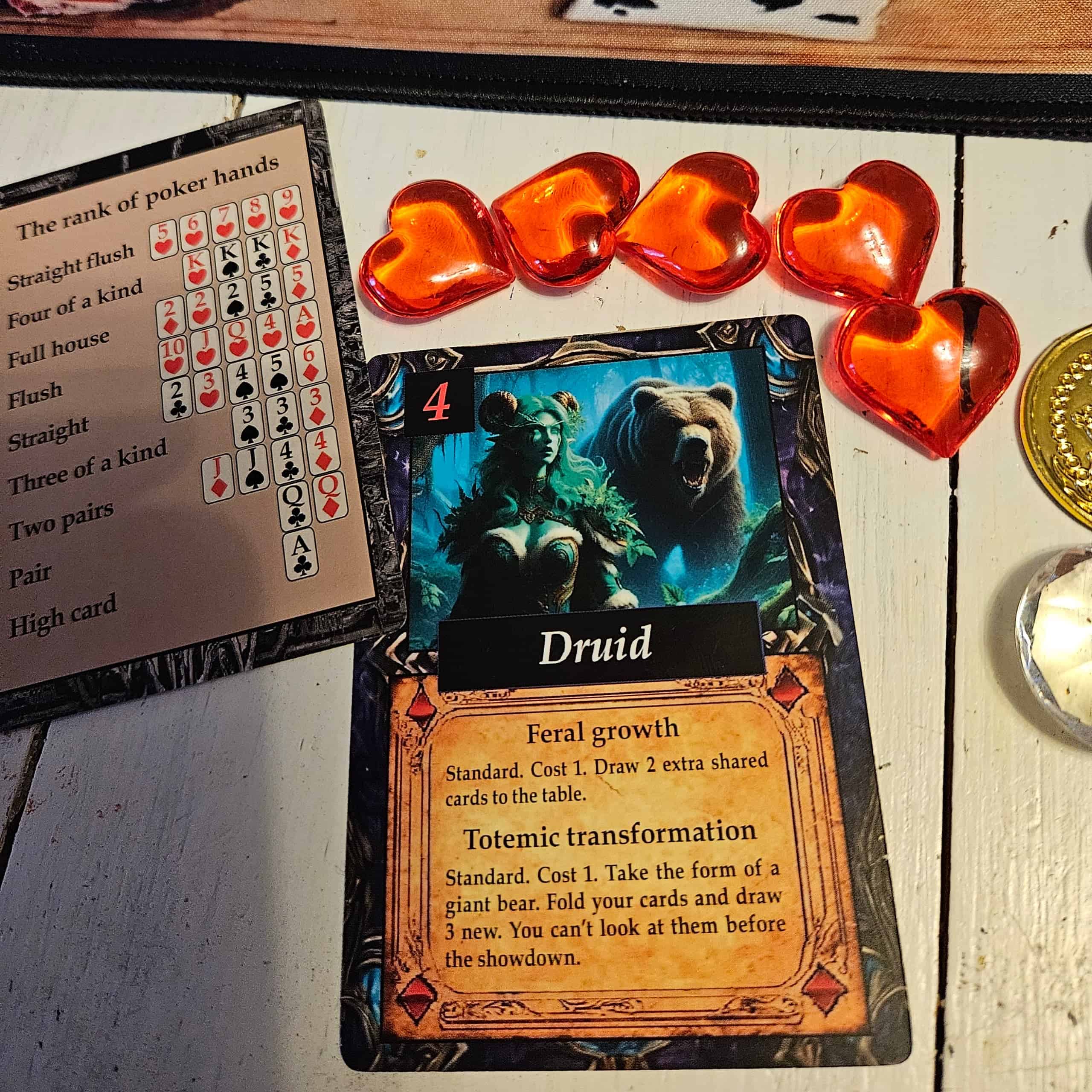 Druid-hahmokortti, vierellään viisi sydännappulaa ja pokerikädet listaava kortti.