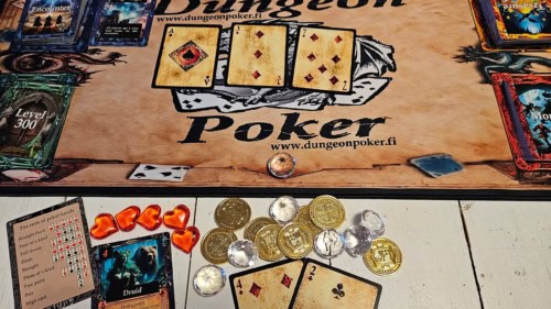Dungeon Pokerin pelialusta, pelin kortteja, kolikoita ja jalokiviä.