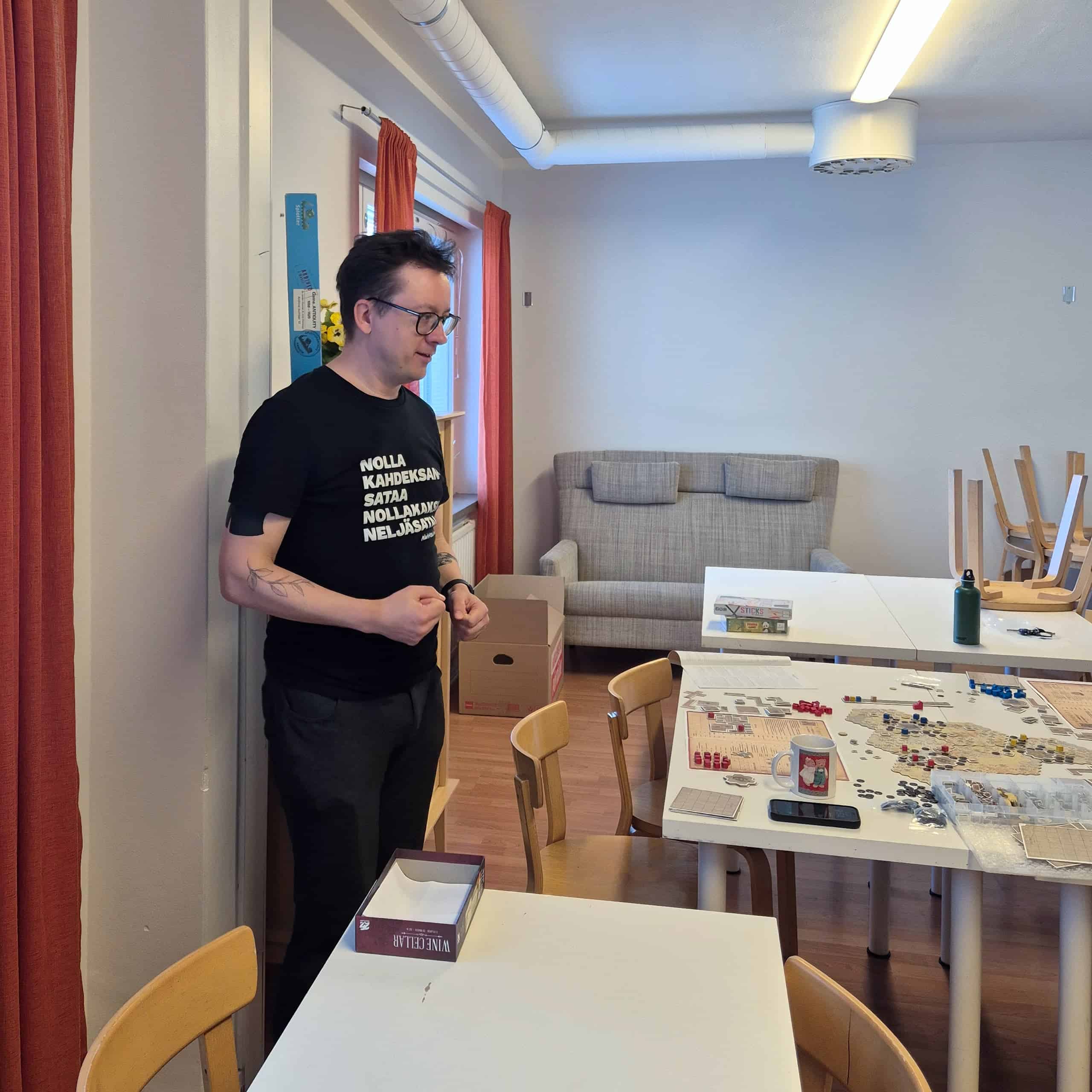 Mikko selittää jotain, vieressä pöydällä Antiquity.