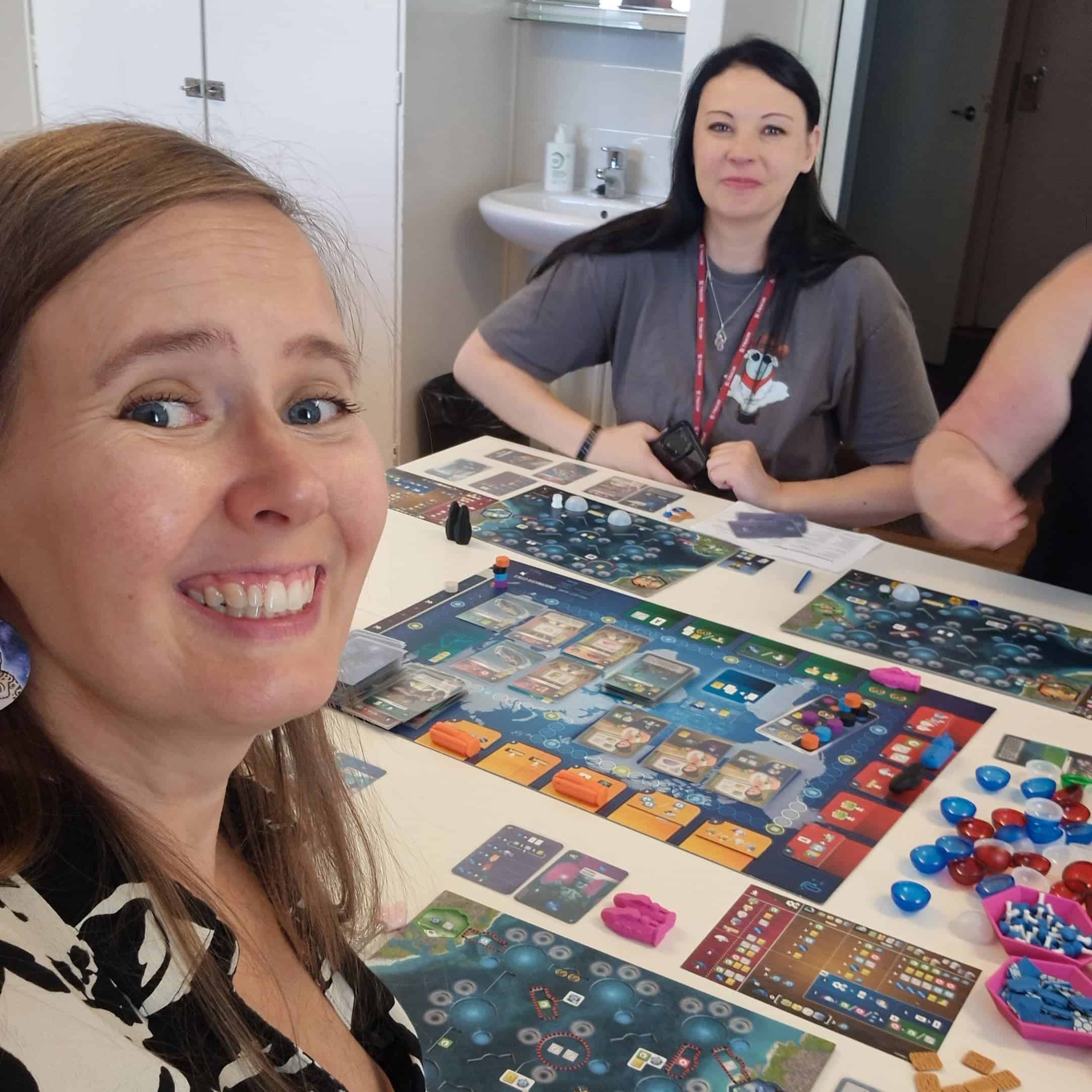 Vilma, Jessica ja Satu (käsivarsi näkyy) pelaamassa Underwater Citiesiä.