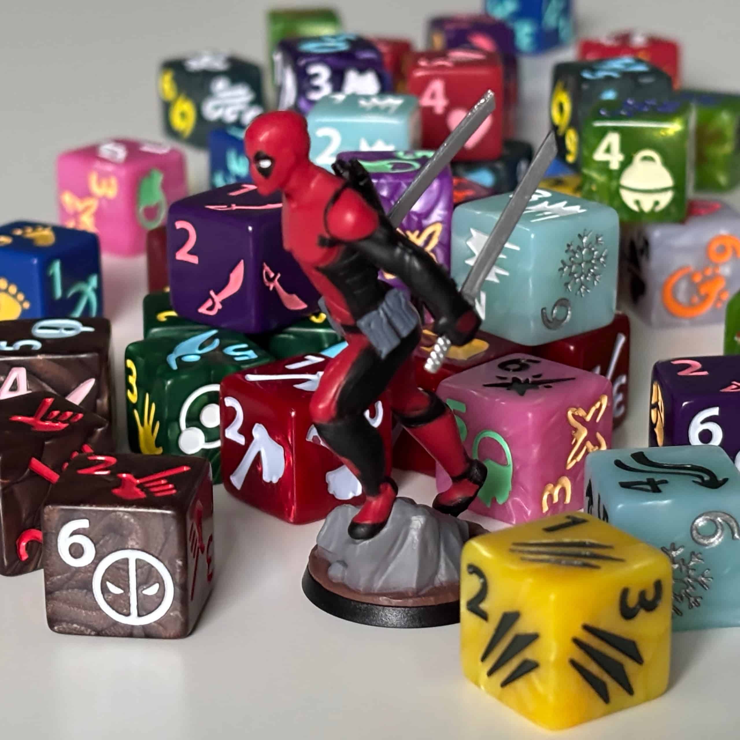 Deadpool-figuuri taustallaan läjä erivärisiä noppia.