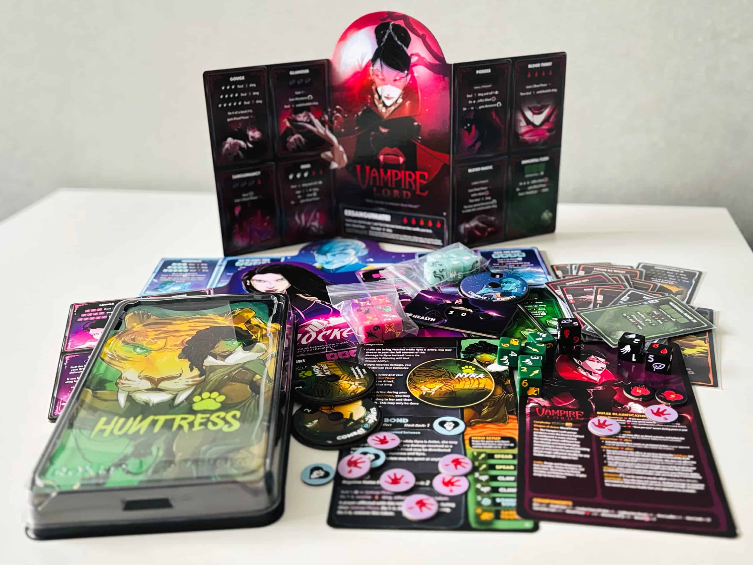 Huntress-hahmon pakkaus ja Huntressin ja Vampire Lordin komponentit esillä pöydällä.